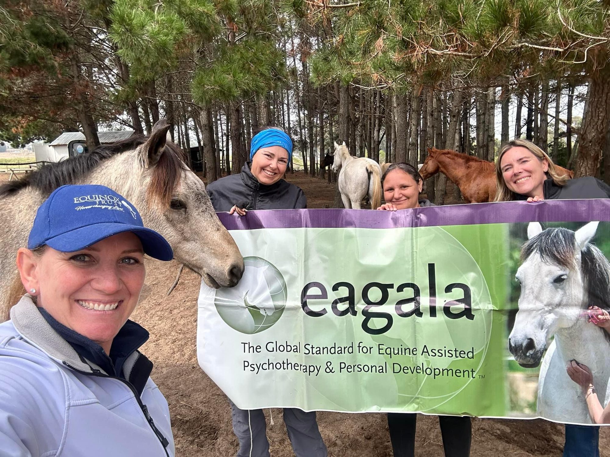 People holding up an Eagala sign in South African location.